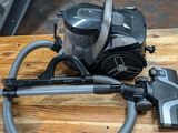 a vacuum that is sitting on a table next to a canister