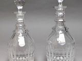 pair of crystal decanters with stoppers on each of them