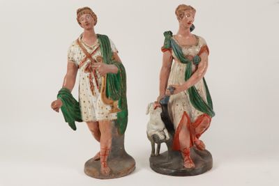 two figurines of a woman and a man with a dog