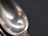 a silver spoon and a fork on a black table