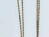 two pieces of silver chain on a white surface with a white background