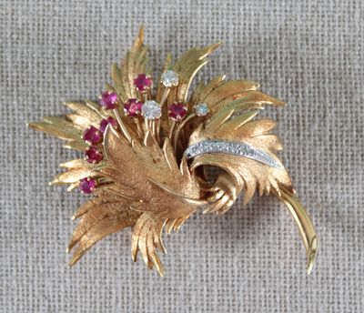 une broche en or ornée de pierres rouges et blanches