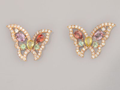 une paire de boucles d'oreilles en forme de papillon ornées de pierres multicolores