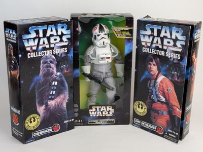 three star wars action figures in boxes on a white surface