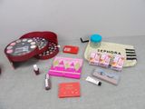 a table with makeup, lipstick, lipstick case, and other items on it