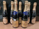 six bouteilles de champagne alignées sur une table
