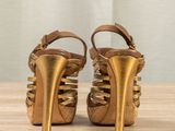 gold leather platform sandals with gold straps on a wooden table
