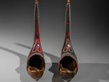 pair of red and gold decorated shoes on a white surface