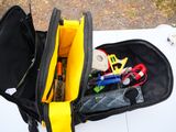 a black bag with tools in it sitting on top of a white car
