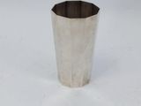 a close up of a silver cup on a white surface