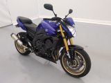 a picture of a blue motorcycle parked in a room
