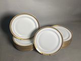 a set of six white and gold plates with gold rims