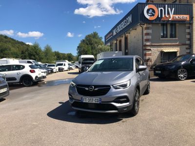 the car is parked in front of a building with a lot of cars parked in front of it