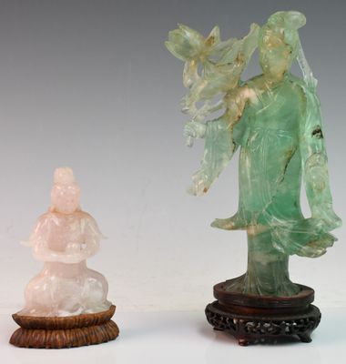 a statue of a woman standing next to a small statue of a man