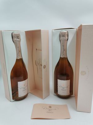 deux bouteilles de champagne dans un coffret rose, avec une carte posée dessus