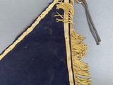 a close up of a blue triangle with fringes on it