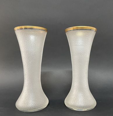 une paire de vases blancs aux bords dorés sur fond noir