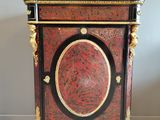 a red and black cabinet sitting on a tiled floor