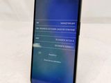 a close up of a cell phone on a stand on a white surface