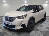 une voiture blanche est garée dans une pièce au sol à carreaux