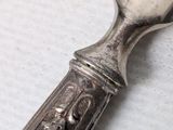 a silver spoon with a silver handle on a table