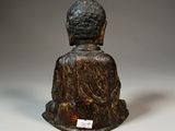 statue of a person sitting in a meditation position on a white surface