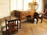 two tables and a dresser in the corner of a room