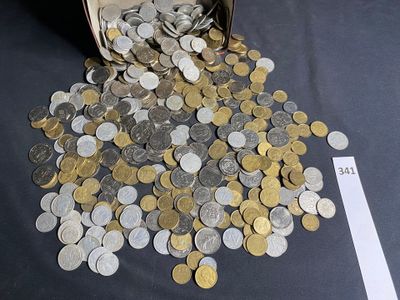 coins spilling out of a bucket on a table next to a piece of paper