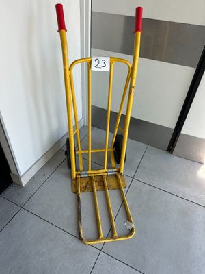 a yellow hand truck that is sitting on the floor
