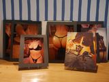 three framed photos of women in lingersuits on a wooden table