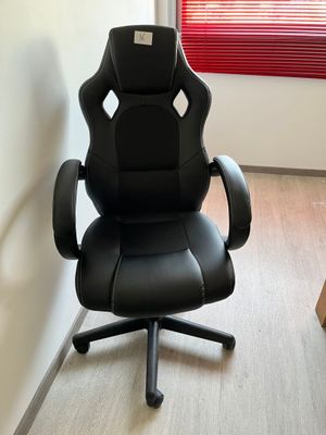 une chaise de bureau noire placée devant une fenêtre