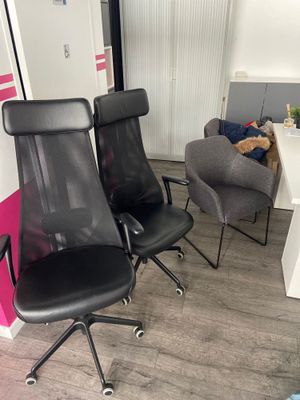 two black office chairs in the corner of a room