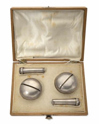 une image représentant un objet métallique dans un coffret en bois, sur fond blanc