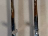 two metal spoons that are on a white surface