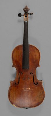 an old violin with a bow on a gray background