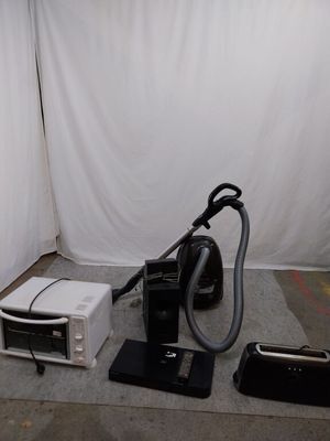 un micro-ondes, un four à micro-ondes et un aspirateur posé par terre