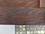 a close up of a wooden bench with a brick wall in the background
