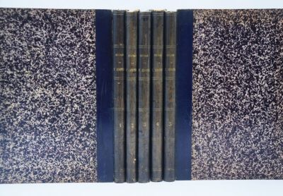 trois livres sont alignés sur une surface blanche