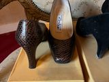 three pairs of women ' s shoes sitting on boxes on a chair