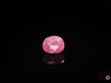 a close up of a pink diamond on a black surface