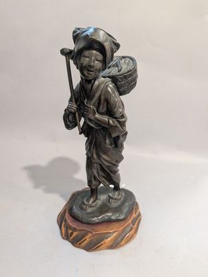 une statue représentant un homme avec un sac sur le dos