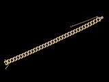 gros plan d'un bracelet en or sur fond noir