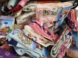 a cardboard box full of children ' s clothing and socks