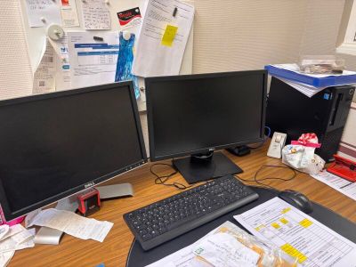 a desk with two computer monitors and a keyboard on it