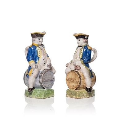 paire de figurines en céramique représentant un homme et une femme assis sur un tonneau