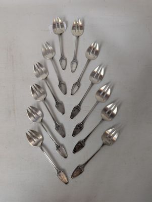 a lot of silver spoons and forks arranged in a circle