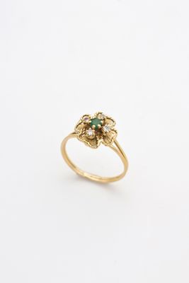 a close up of a gold ring with a green stone