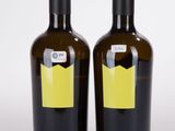 deux bouteilles de vin posées l'une à côté de l'autre sur une surface blanche
