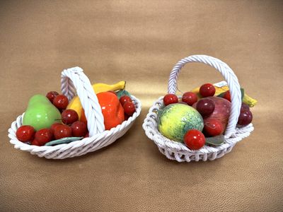 two baskets filled with different types of fruit on a table