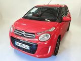 a red car that is parked in a white room